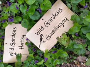 Photo of two engraved wooden plaques surrounded by flowers